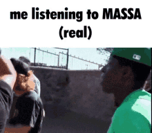 a man in a green hat stands in front of a crowd of people and says me listening to massa ( real )