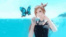 a woman in a black dress is standing on a beach next to a butterfly .