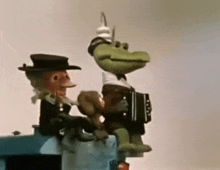 a frog is playing an accordion next to a man