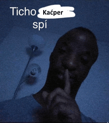 a man holds his finger to his mouth with the words " icho kacper spi " written above him