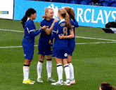 a group of female soccer players are standing on a field and one of them has the number 8 on her jersey