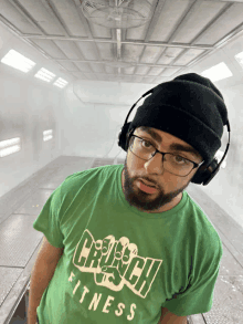 a man wearing a green crunch fitness t-shirt