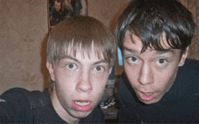 two boys are posing for a picture and one of them is making a face