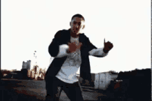 a man in a white shirt and black jacket is dancing