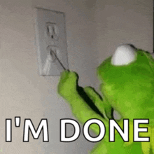 kermit the frog is plugging a cord into a wall outlet .