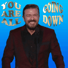 a man in a suit stands in front of a microphone with the words " you are all going down " behind him