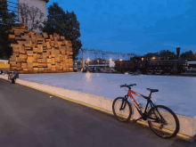 a red and black bicycle is parked on a sidewalk in front of a train