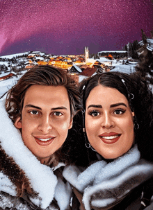 a man and a woman are posing for a picture in front of a snowy village