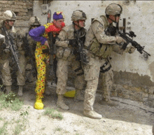 a group of soldiers are standing around a clown who is wearing a clown costume