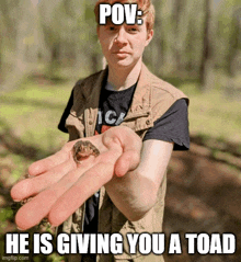 a young man is holding a small toad in his hand with the caption " pov : he is giving you a toad "