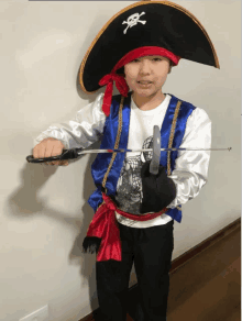 a boy dressed as a pirate holds a sword