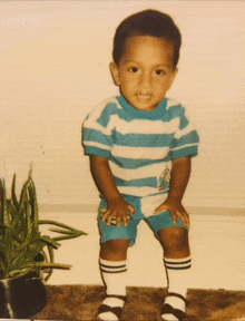 a young boy wearing a striped shirt and knee high socks