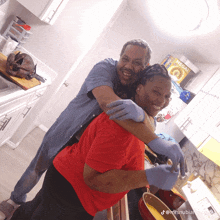 a man is hugging a woman in a kitchen with a box of cereal on the counter