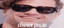 a close up of a man wearing sunglasses and smiling in russian .