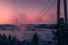 a bridge over a body of water with a pink sky in the background