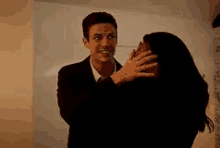 a man in a suit and tie is hugging a woman .