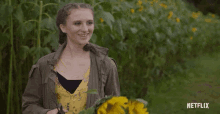 a woman is holding a bouquet of sunflowers in front of a field of sunflowers with netflix written on the bottom