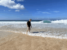 a man standing on a beach looking out to the ocean