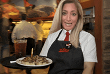 a woman wearing an apron that says slasher jo holds a plate of food