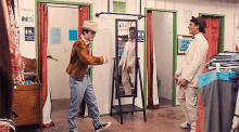 a man in a cowboy hat is standing in a dressing room next to a sign that says changing rooms