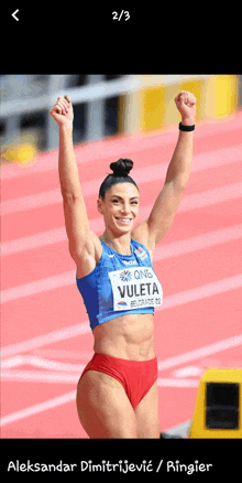 a woman in a blue top and red shorts with the name voleta on it