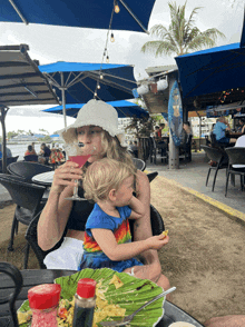 a woman drinking a martini while holding a small child