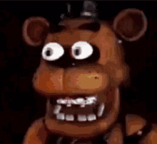 five nights at freddy 's freddy the bear with big eyes and a hat on his head .