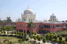 a large building with a dome on top of it is surrounded by palm trees