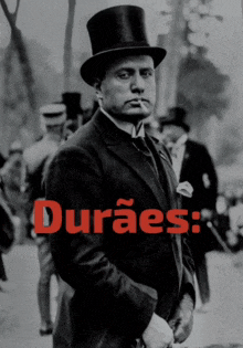 a black and white photo of a man wearing a top hat with the words duraes written in red