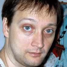 a close up of a man 's face with blue eyes and a beard