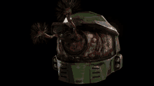 a green helmet with a bloody face and a few spikes coming out of it