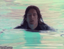 a man in a wet suit is swimming in a pool