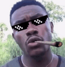 a man wearing sunglasses and holding a cigarette in his mouth .