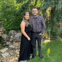 a man and a woman pose for a picture in a park