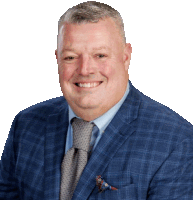 a man in a blue suit and tie is smiling for the camera