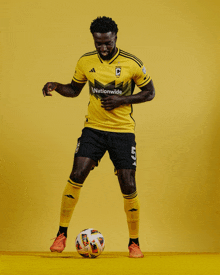 a soccer player in a yellow jersey with the word nationwide on it