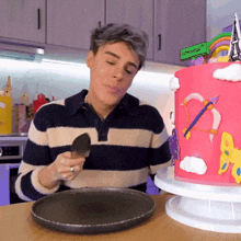 a man in a striped shirt is eating a piece of cake in front of a sign that says cornell