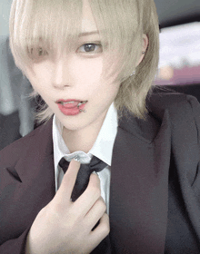 a girl with a piercing in her lip is wearing a suit