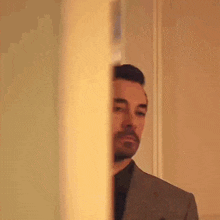 a man in a suit is standing in front of a door with his eyes closed