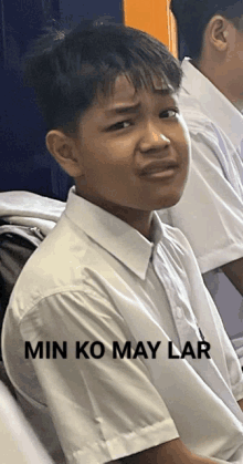 a boy in a white shirt with the words min ko may lar written on the bottom