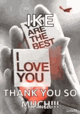 a person is holding a card that says `` i love you '' and says `` thank you so much '' .