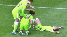 a group of women are playing soccer on a field and one of the players is laying on the ground .