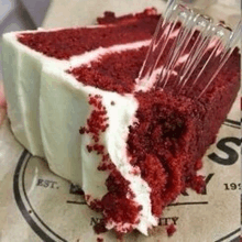 a slice of red velvet cake with a fork in it .