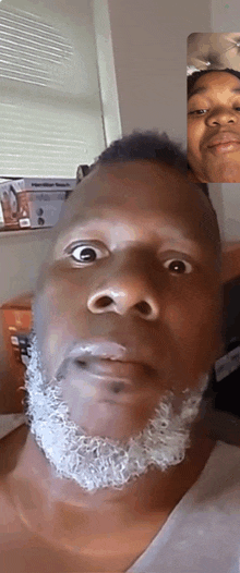 a man with a beard is making a funny face during a video call .