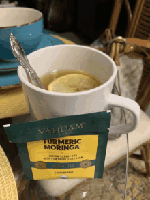 a cup of turmeric moringa herbal tea with a spoon