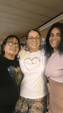 three women posing for a picture with one wearing a shirt that says dream love and happiness