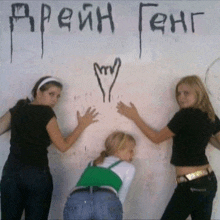 three girls are standing in front of a wall with graffiti on it that says " arein feng "