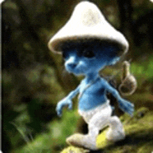 a smurf wearing a mushroom hat is walking in the woods .