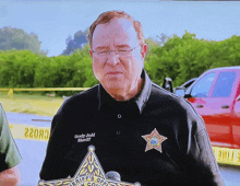 a man in a sheriff 's uniform holds a microphone