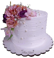 a white cake with pink and purple flowers and pearls by max sibel